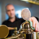 Bar tender cleaning beer pump